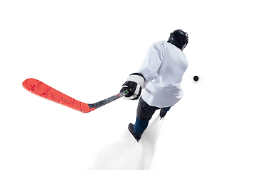 Image showing Unrecognizable male hockey player with the stick on ice court and white background