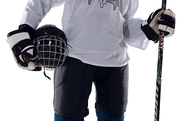 Image showing Unrecognizable male hockey player with the stick on ice court and white background