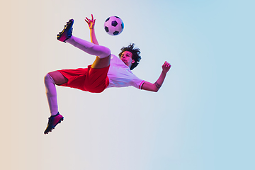 Image showing Football or soccer player on gradient background in neon light - motion, action, activity concept