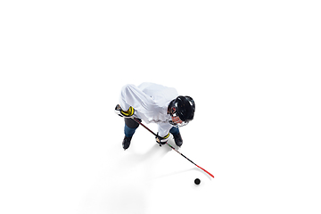 Image showing Unrecognizable male hockey player with the stick on ice court and white background