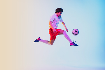 Image showing Football or soccer player on gradient background in neon light - motion, action, activity concept