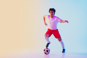 Image showing Football or soccer player on gradient background in neon light - motion, action, activity concept