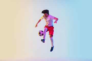 Image showing Football or soccer player on gradient background in neon light - motion, action, activity concept