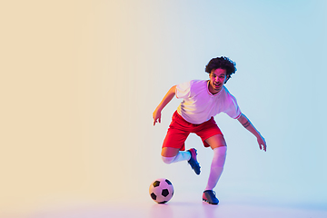 Image showing Football or soccer player on gradient background in neon light - motion, action, activity concept