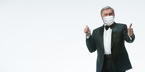 Image showing Elegance senior man waiter in protective face mask on white background. Flyer with copyspace.