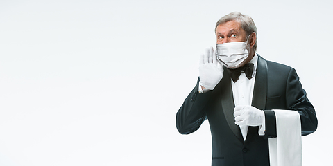 Image showing Elegance senior man waiter in protective face mask on white background. Flyer with copyspace.