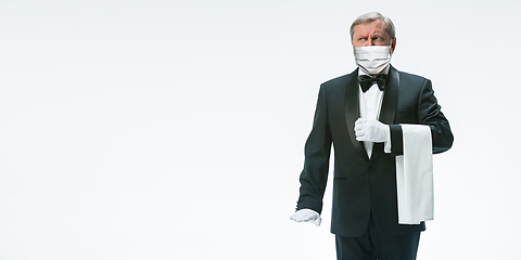 Image showing Elegance senior man waiter in protective face mask on white background. Flyer with copyspace.