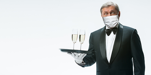 Image showing Elegance senior man waiter in protective face mask on white background. Flyer with copyspace.