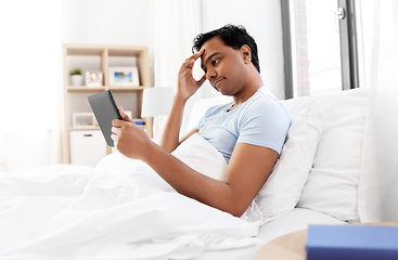 Image showing indian man with tablet pc in bed at home