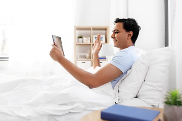 Image showing happy man with tablet pc in bed having video call