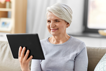 Image showing happy senior woman with tablet pc at home