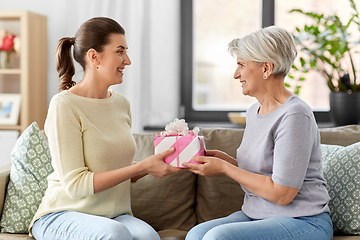 Image showing adult daughter giving present to her senior mother