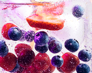 Image showing Close up view of the cold and fresh lemonade with bright berries in neon light