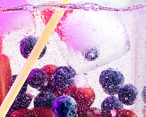 Image showing Close up view of the cold and fresh lemonade with bright berries in neon light
