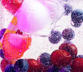 Image showing Close up view of the cold and fresh lemonade with bright berries in neon light