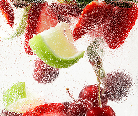 Image showing Close up view of the cold and fresh lemonade with bright berries in neon light