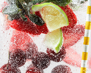 Image showing Close up view of the cold and fresh lemonade with bright berries in neon light