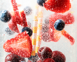 Image showing Close up view of the cold and fresh lemonade with bright berries in neon light