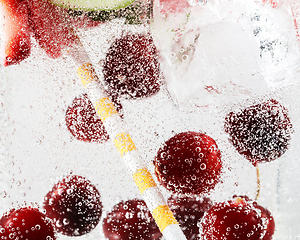 Image showing Close up view of the cold and fresh lemonade with bright berries in neon light