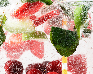 Image showing Close up view of the cold and fresh lemonade with bright berries in neon light