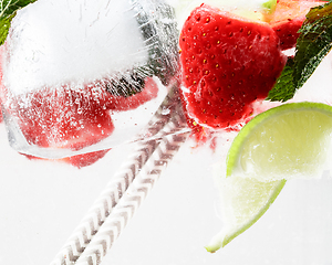 Image showing Close up view of the cold and fresh lemonade with bright berries in neon light