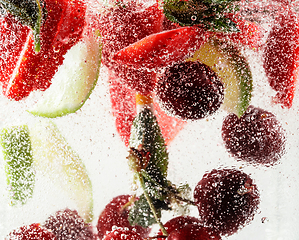 Image showing Close up view of the cold and fresh lemonade with bright berries in neon light