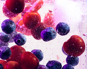 Image showing Close up view of the cold and fresh lemonade with bright berries in neon light