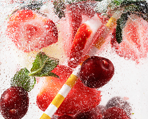 Image showing Close up view of the cold and fresh lemonade with bright berries in neon light