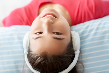 Image showing girl in headphones listening to music at home