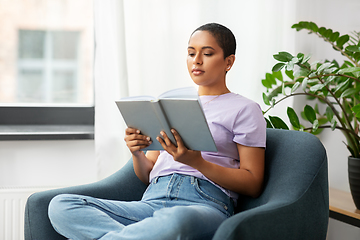 Image showing african american woman reading book at home