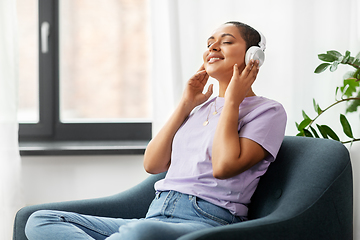 Image showing woman in headphones listening to music at home