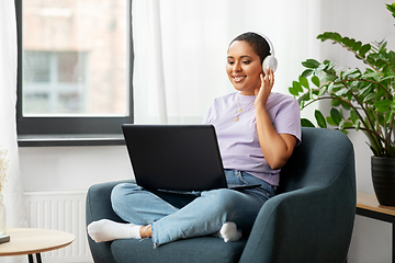 Image showing woman with laptop listening to music at home