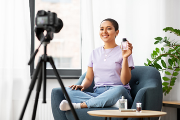 Image showing female beauty blogger with camera and perfume