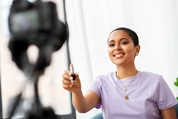 Image showing female beauty blogger with camera and lipstick