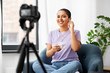 Image showing female blogger with camera video blogging at home