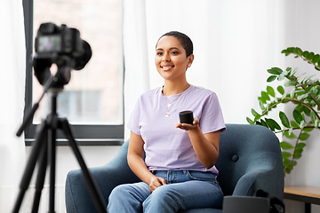 Image showing female blogger with camera video blogging at home