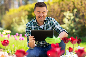 Image showing man with tablet pc and flowers at summer garden