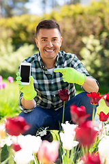 Image showing middle-aged man with smartphone at flower garden