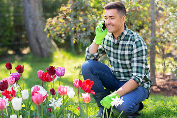 Image showing man with flowers calling on smartphone at garden