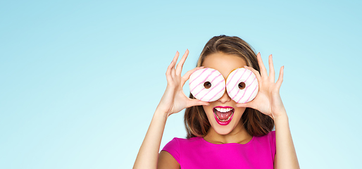 Image showing happy woman or teen girl looking through donuts