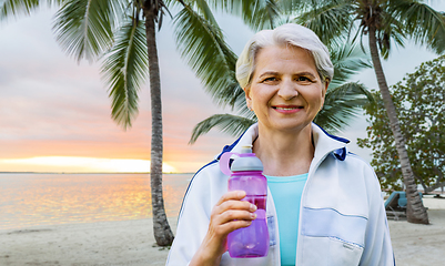 Image showing sporty senior woman with bottle of water at park