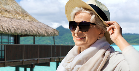 Image showing happy senior woman in sunglasses and hat on beach