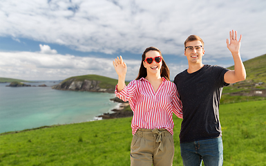 Image showing happy couple waving hands in ireland