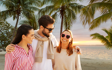 Image showing happy friends walking along summer beach