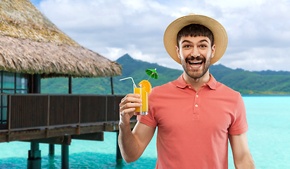 Image showing happy man in straw hat with orange juice cocktail