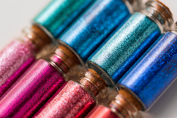 Image showing set of glitters in bottles over white background