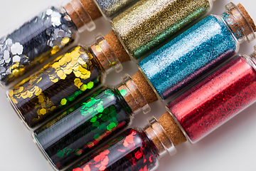 Image showing set of different glitters in small glass bottles