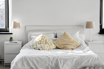 Image showing cozy bedroom with cushions and bed linen at home