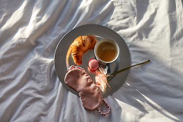 Image showing croissant, coffee and eye sleeping mask in bed