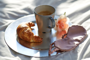 Image showing croissant, coffee and eye sleeping mask in bed